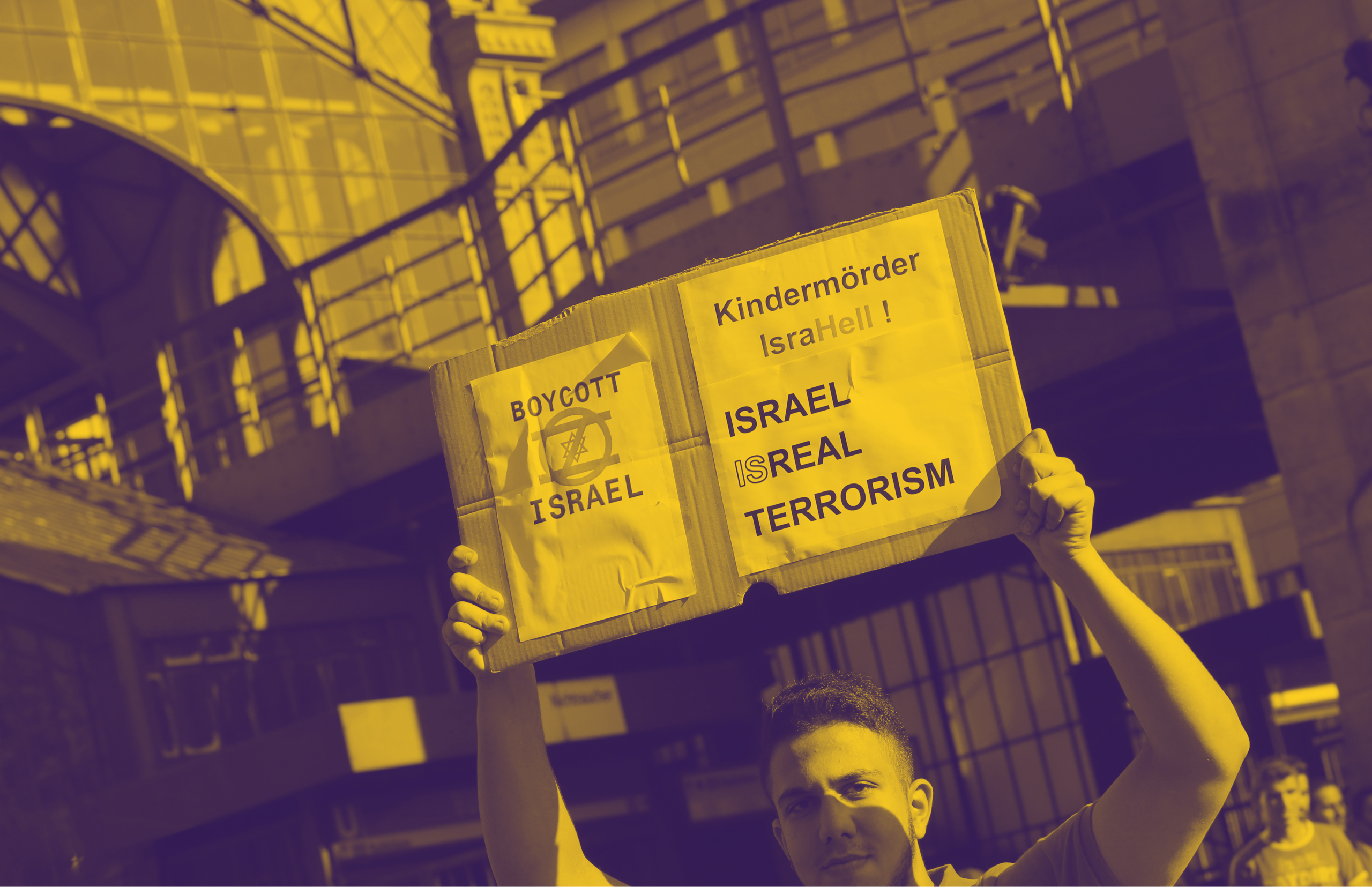 Ein Demonstrant auf einer Demonstration in Berlin 2014 hält ein Plakat, auf dem "Boycott Israel, Kindermörder IsraHell!, Israel ISreal Terrorism" steht.